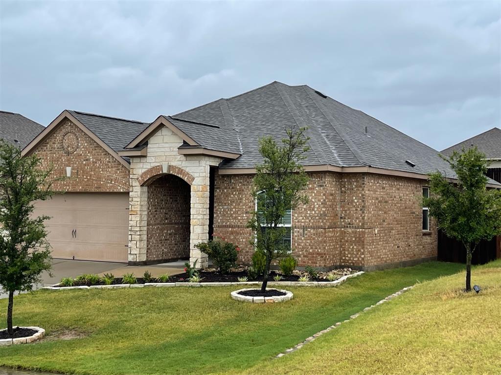 a front view of a house with a garden and yard