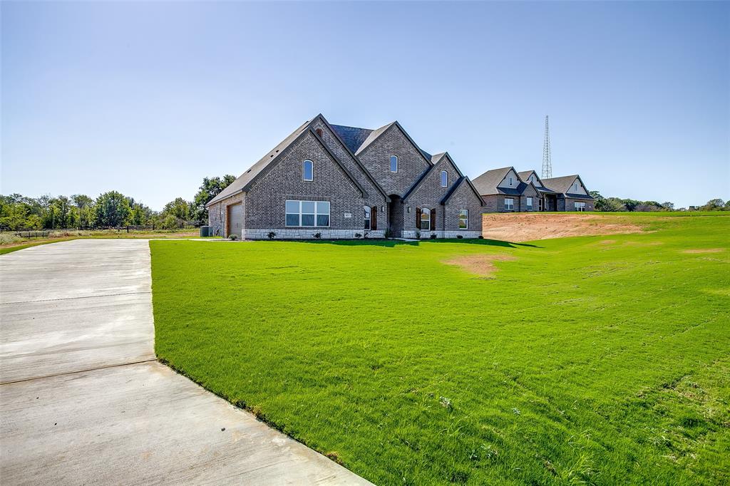 a view of a house with a big yard and large trees