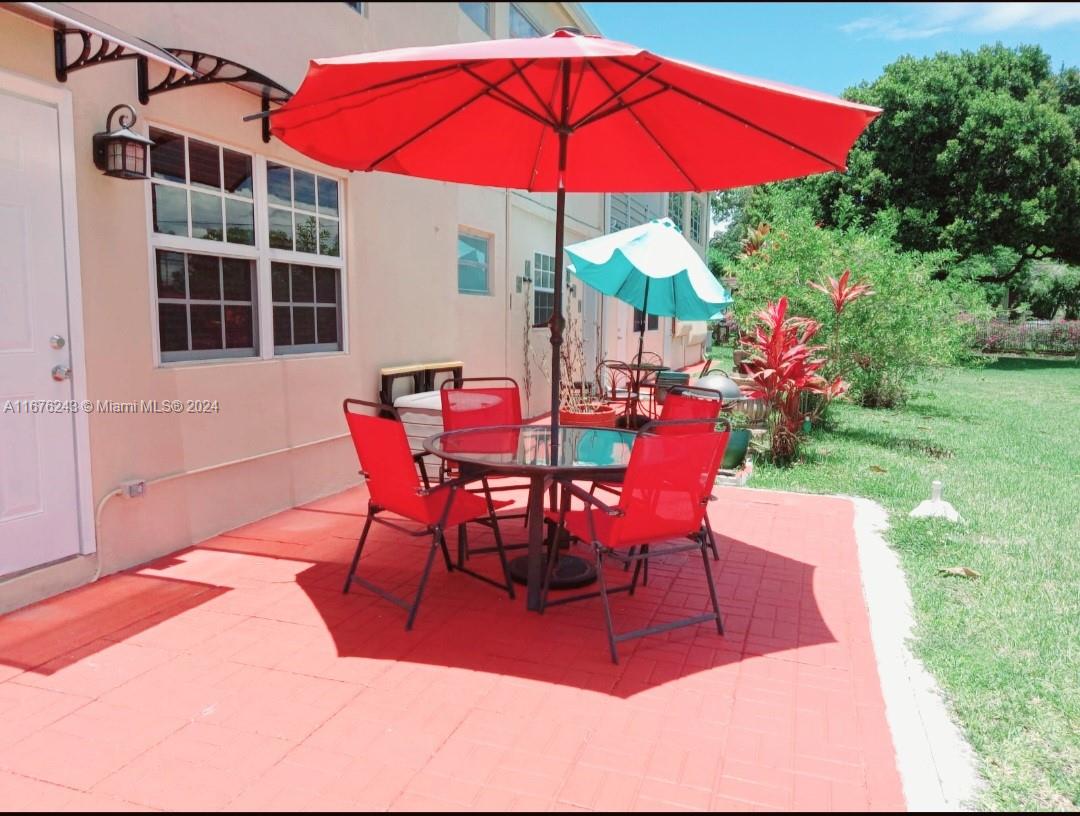 a patio with tables and chairs and a umbrella