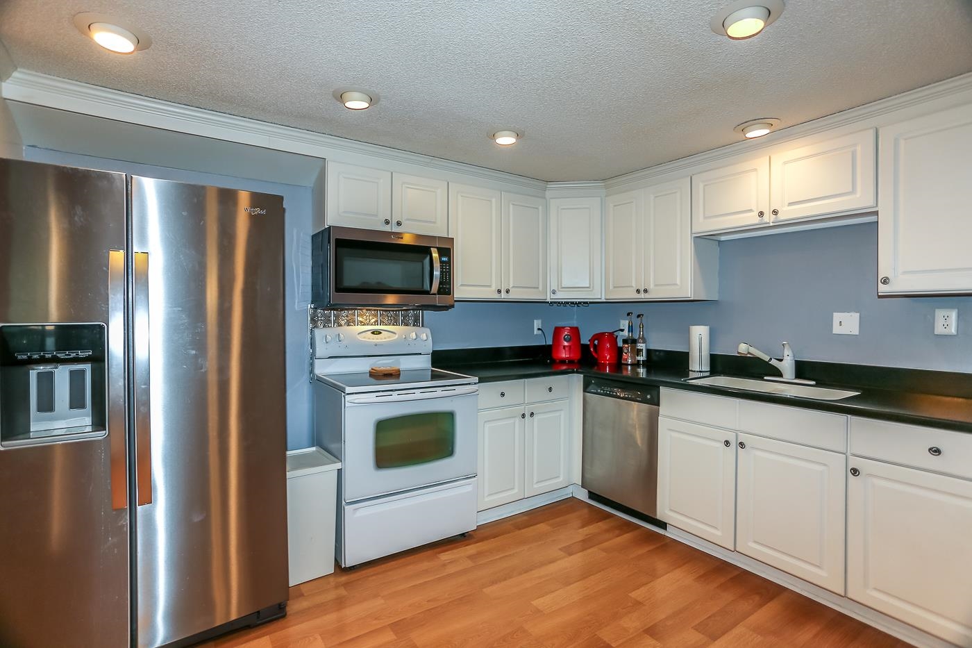 a kitchen with granite countertop stainless steel appliances and sink