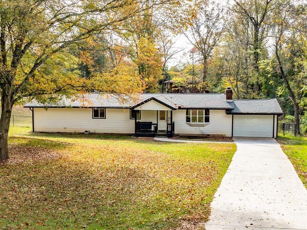 a front view of house with yard and trees in the background