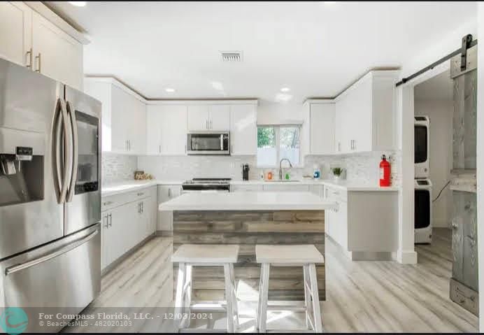 a kitchen with refrigerator cabinets and wooden floor