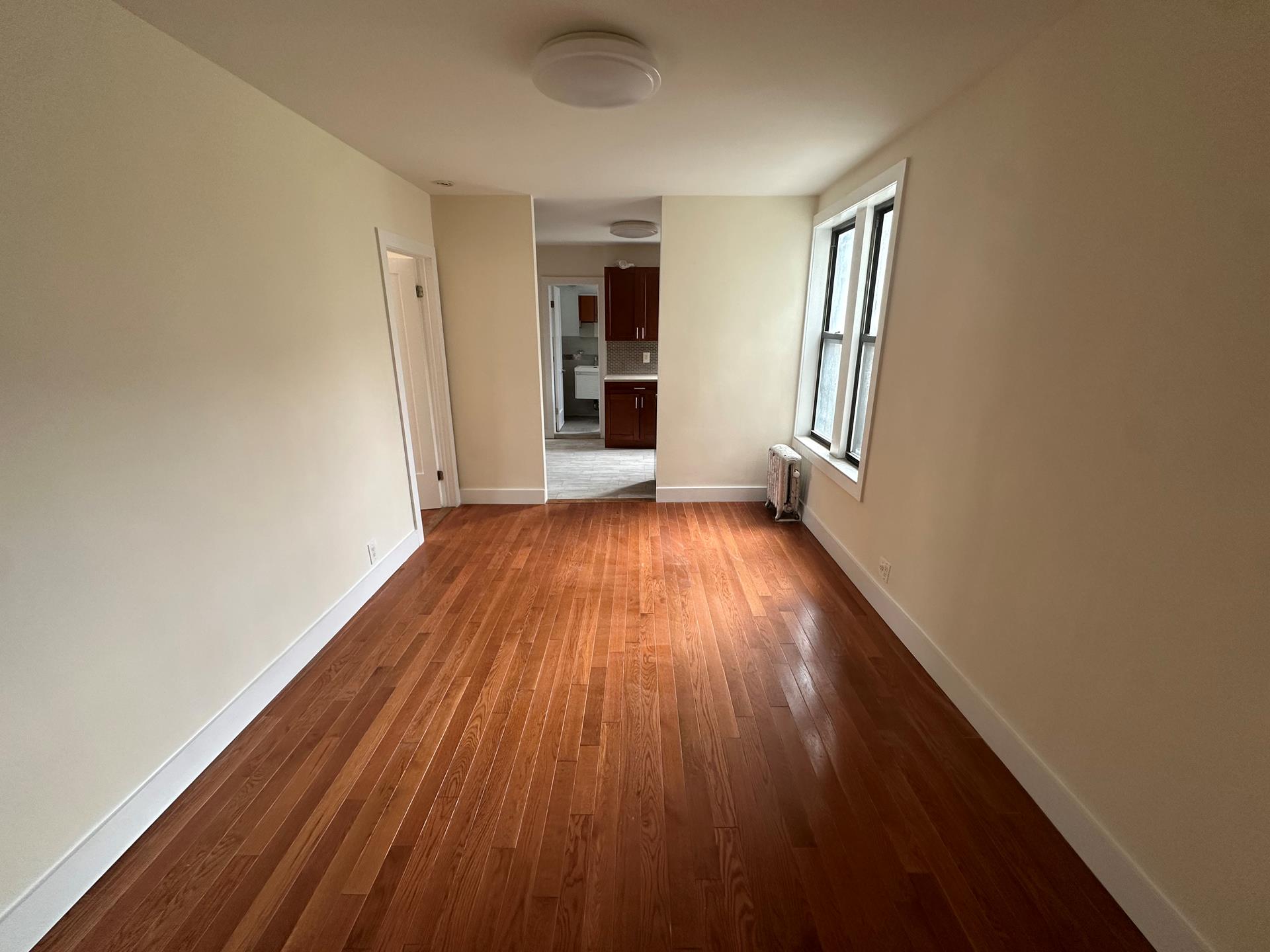 wooden floor in an empty room with a window