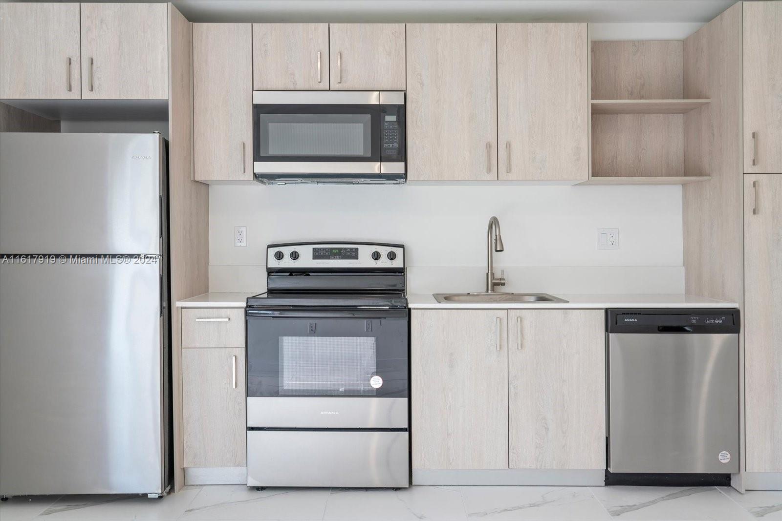 a kitchen with appliances a refrigerator and cabinets