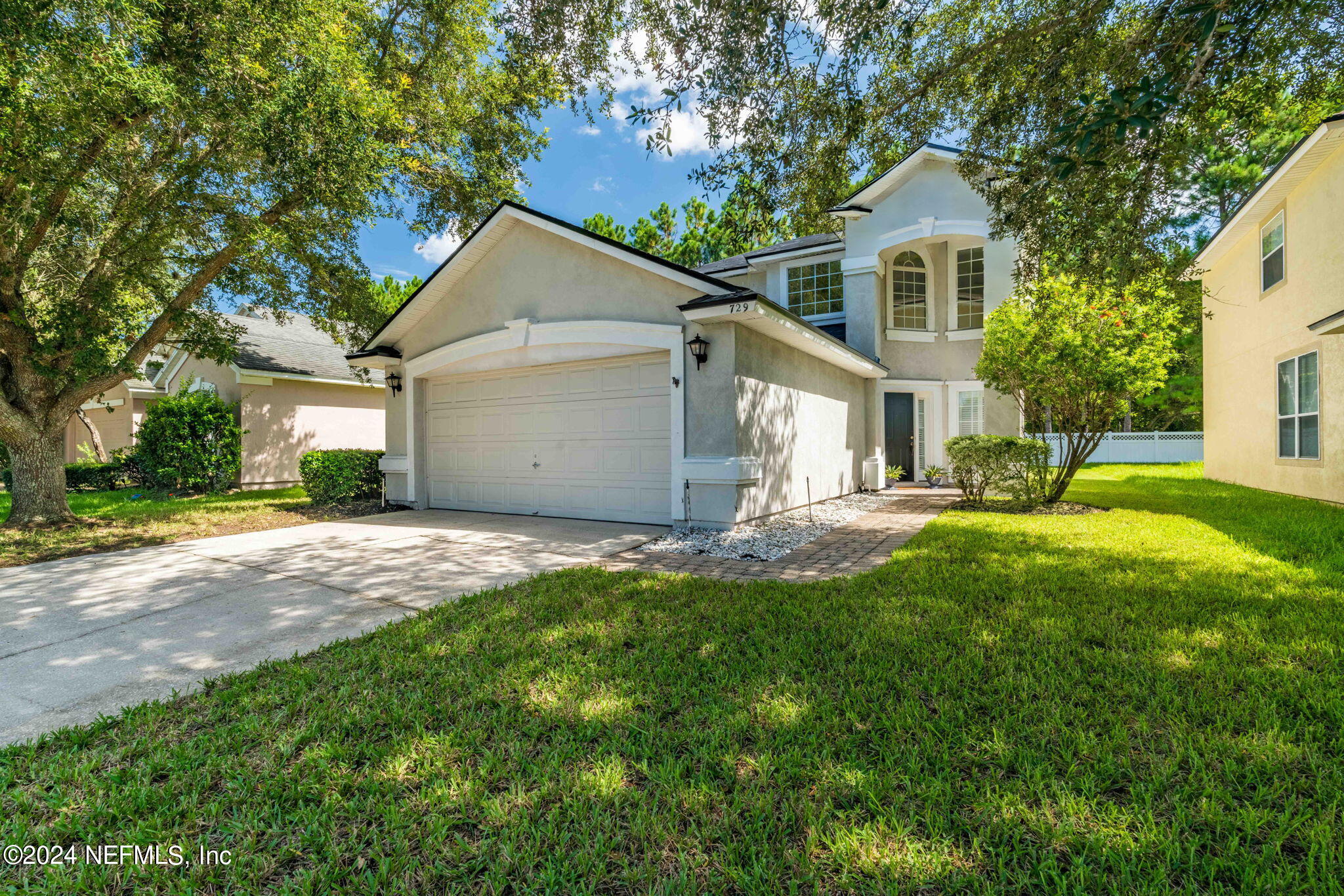 a front view of house with yard and green space