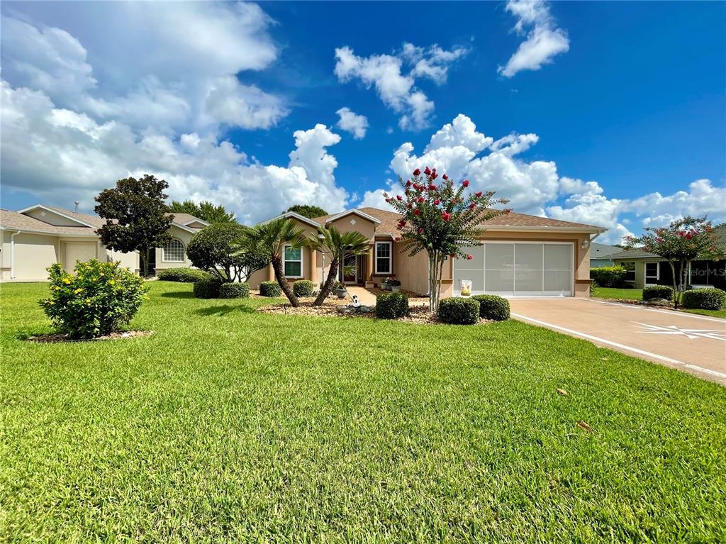 a view of a house with a big yard and large tree