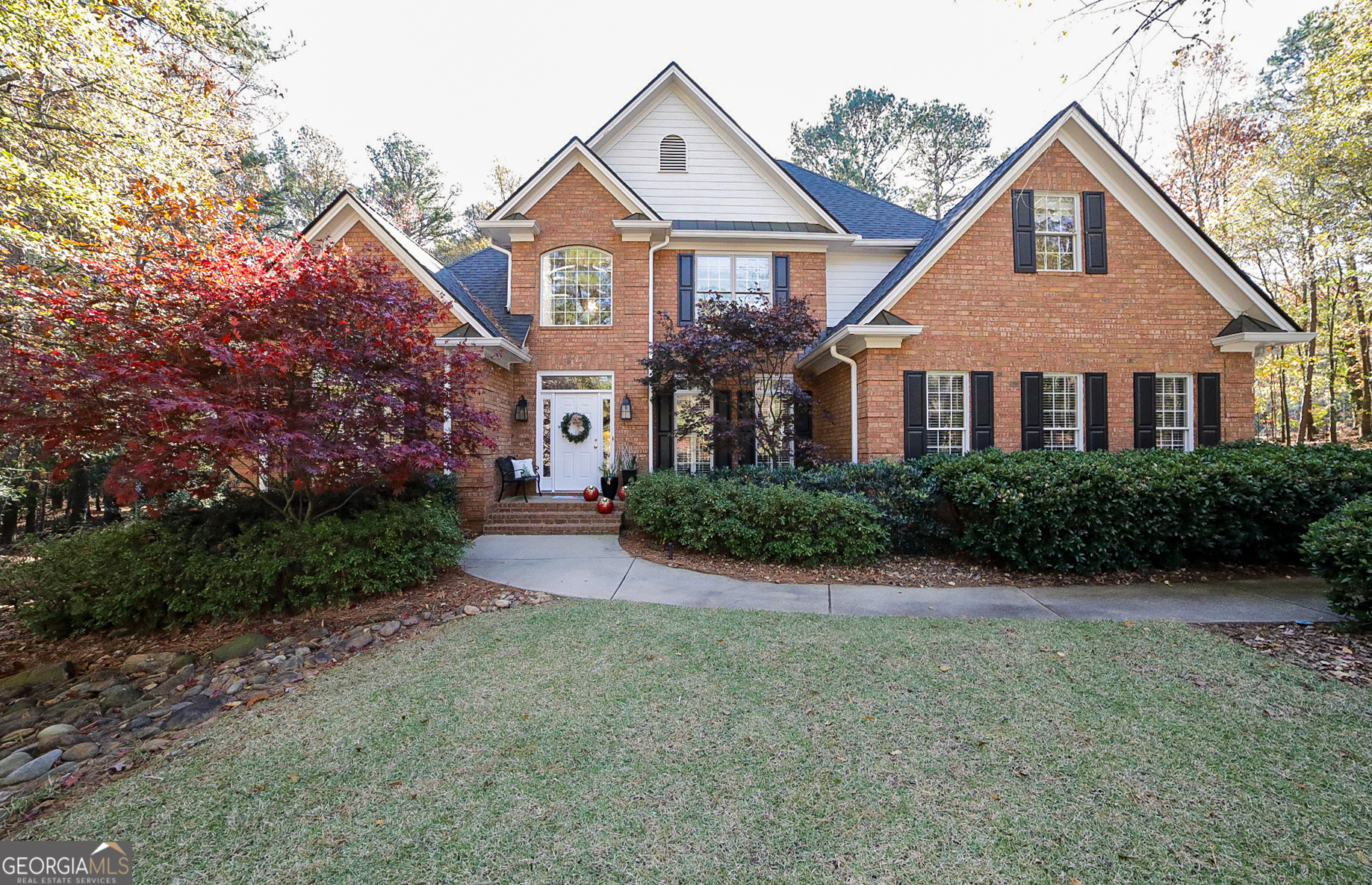 a front view of a house with yard and green space