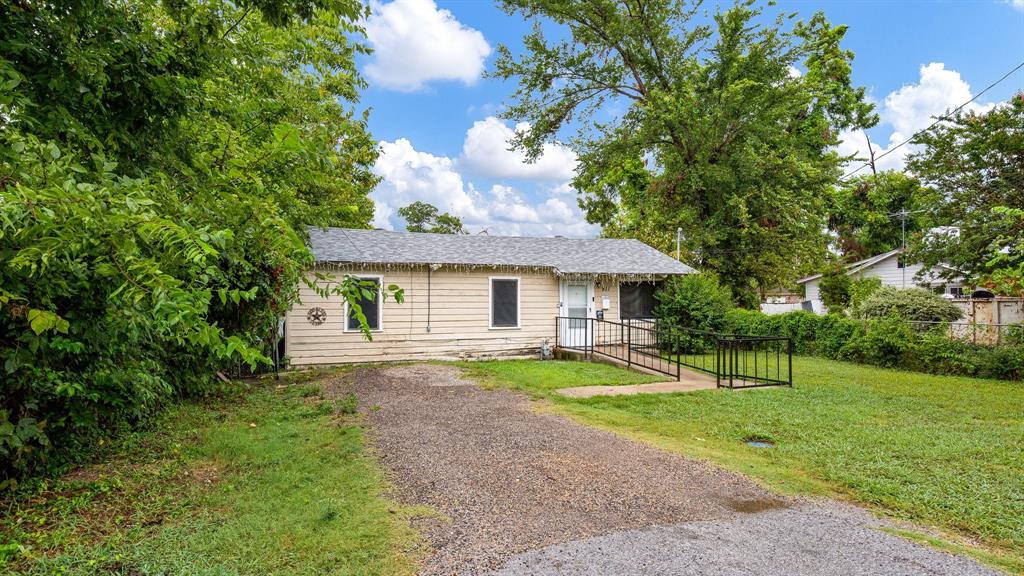 a front view of a house with a yard and trees