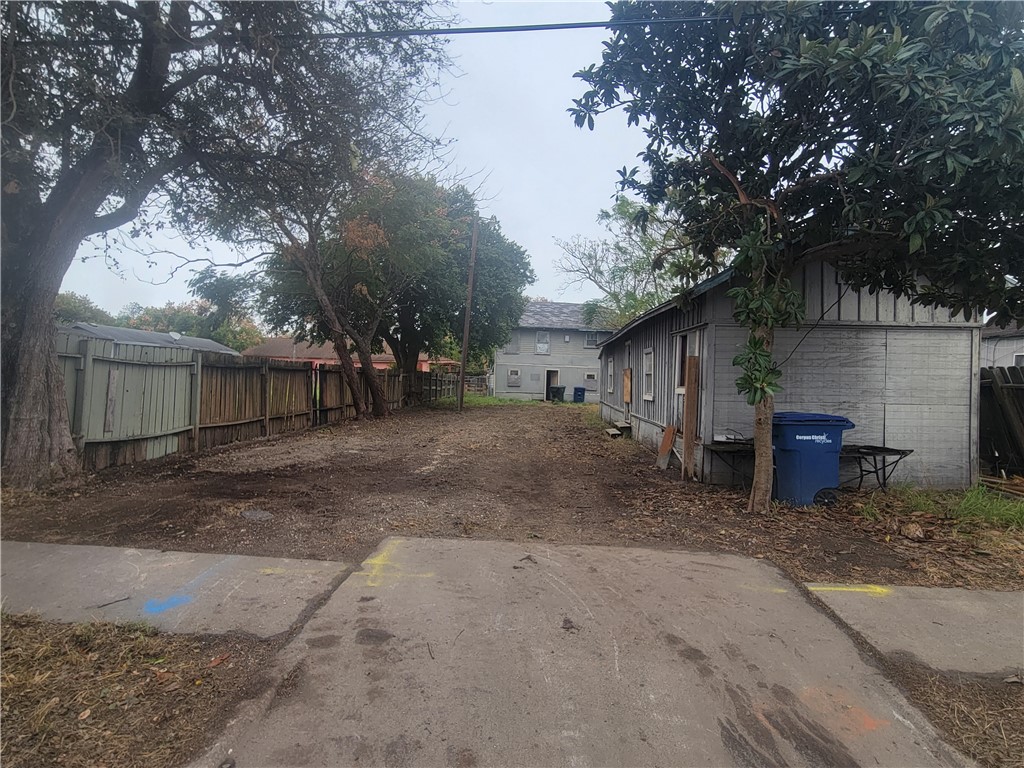 a view of a house with backyard and a tree