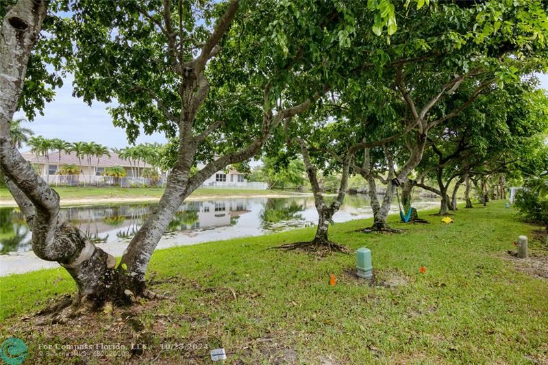 a backyard of a house with lots of green space and lake view