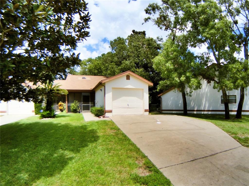 a front view of a house with yard and green space