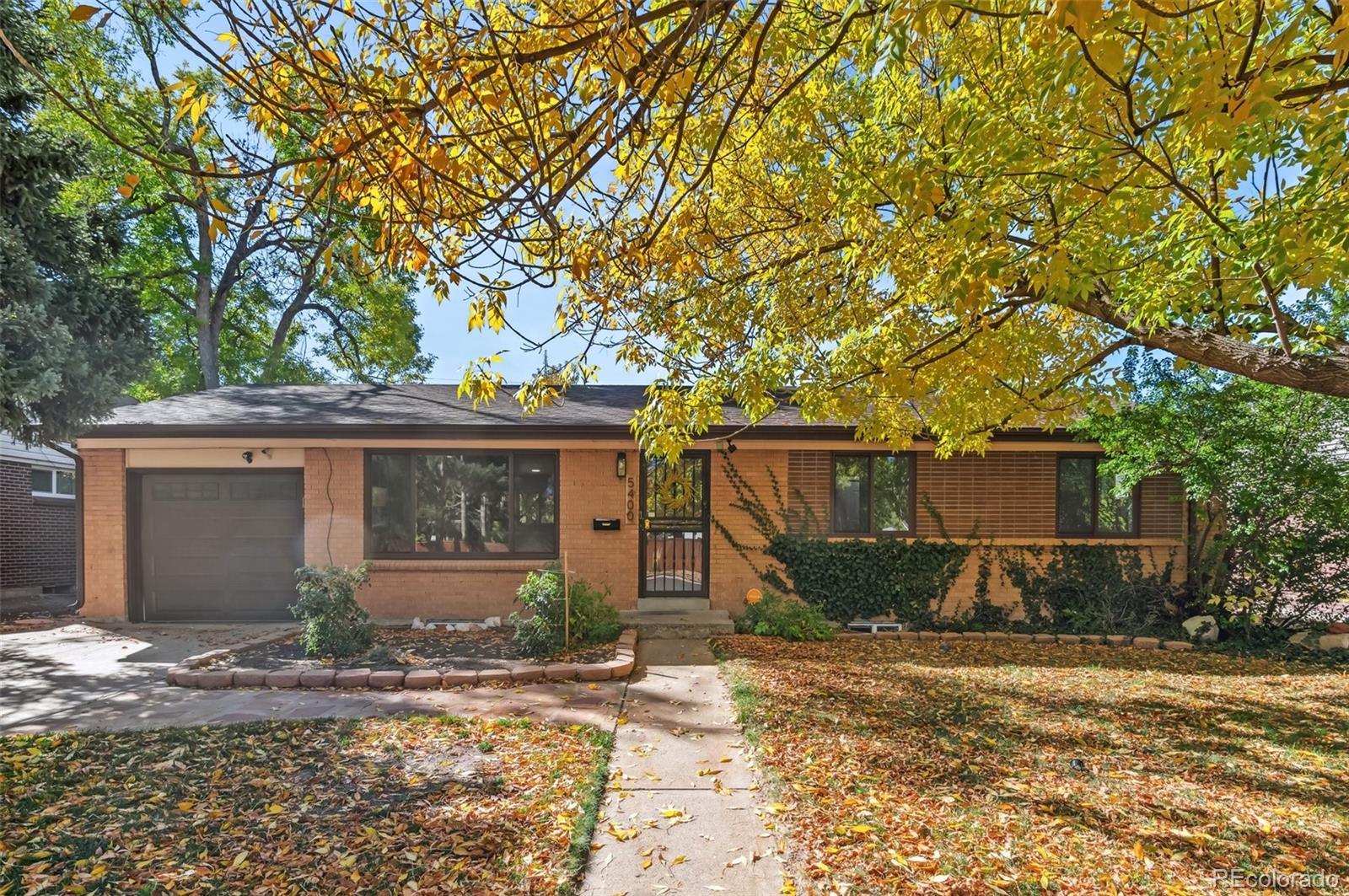 front view of a house with a yard and an trees