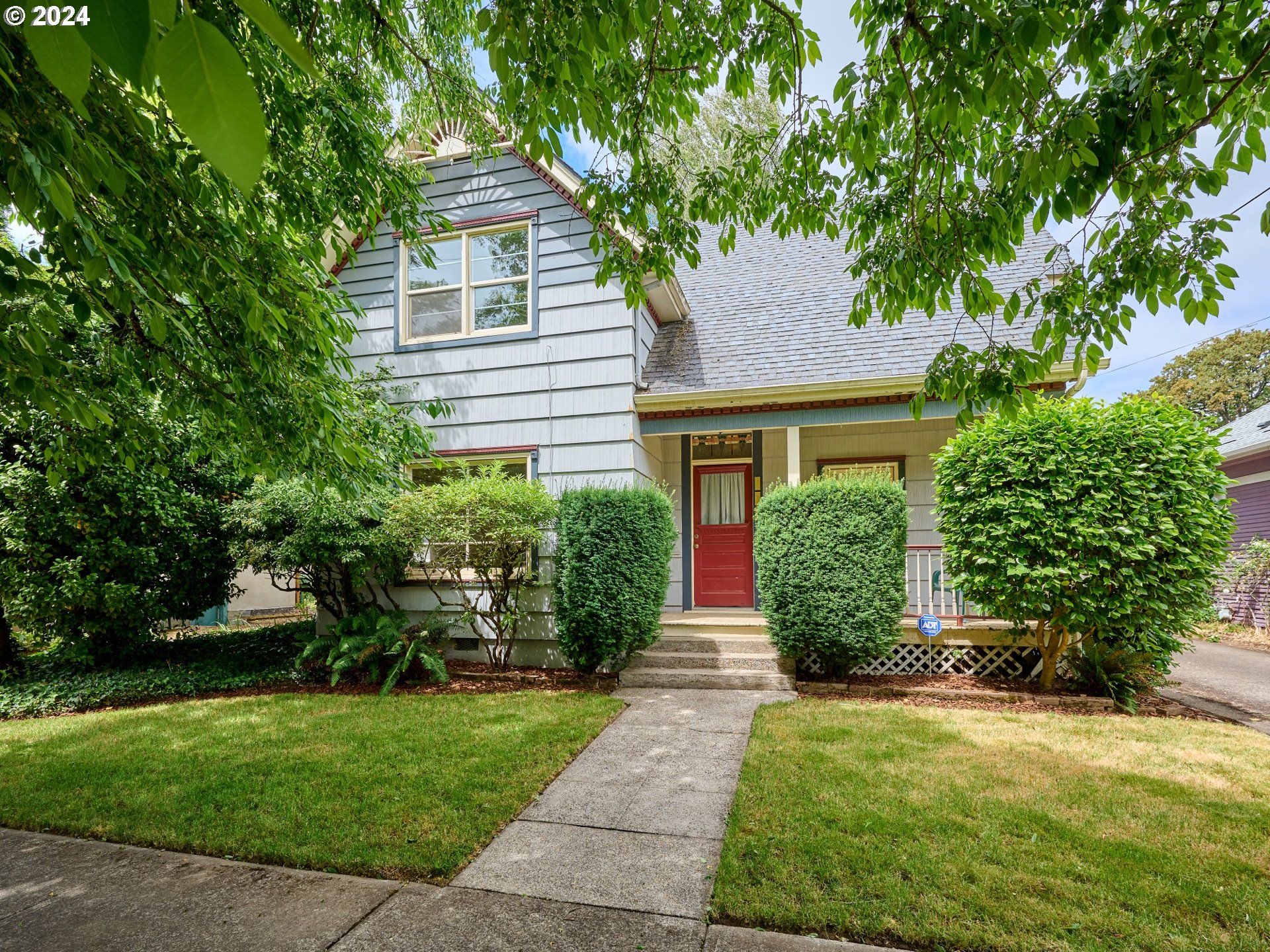 a front view of a house with a yard and trees