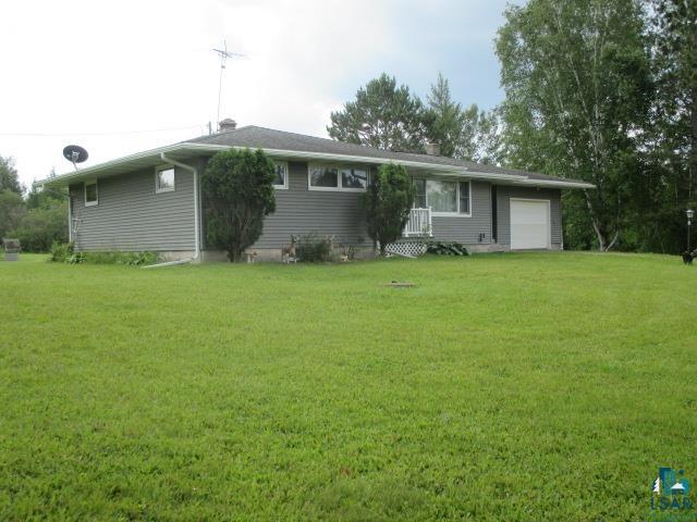 View of front of house with a garage and a front lawn