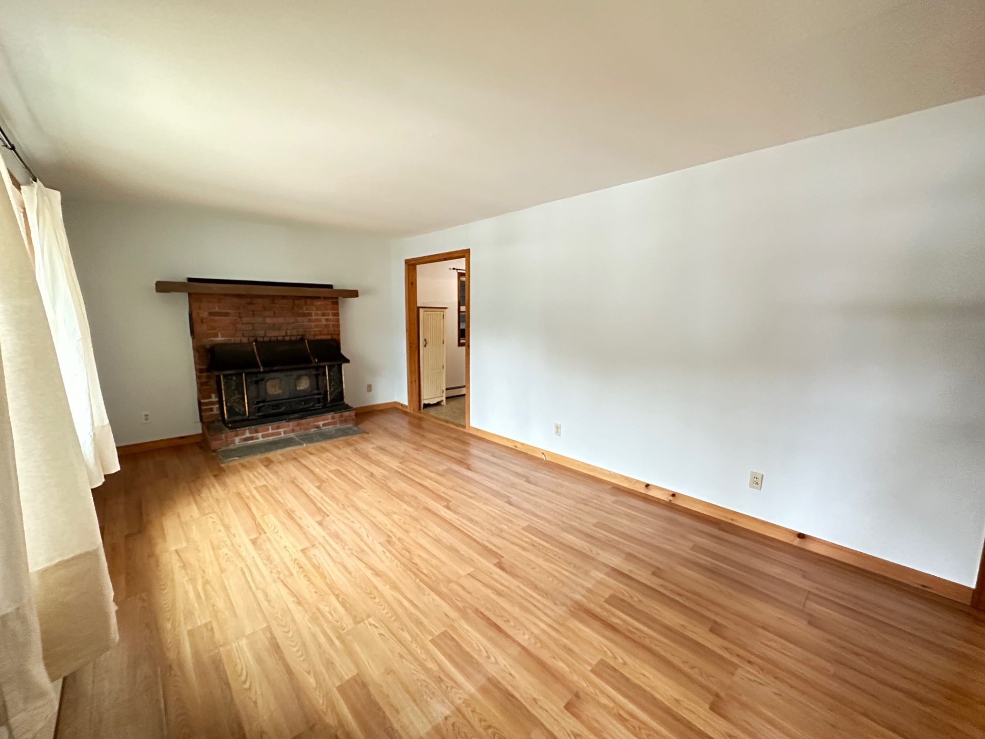 wooden floor in an empty room with a fireplace