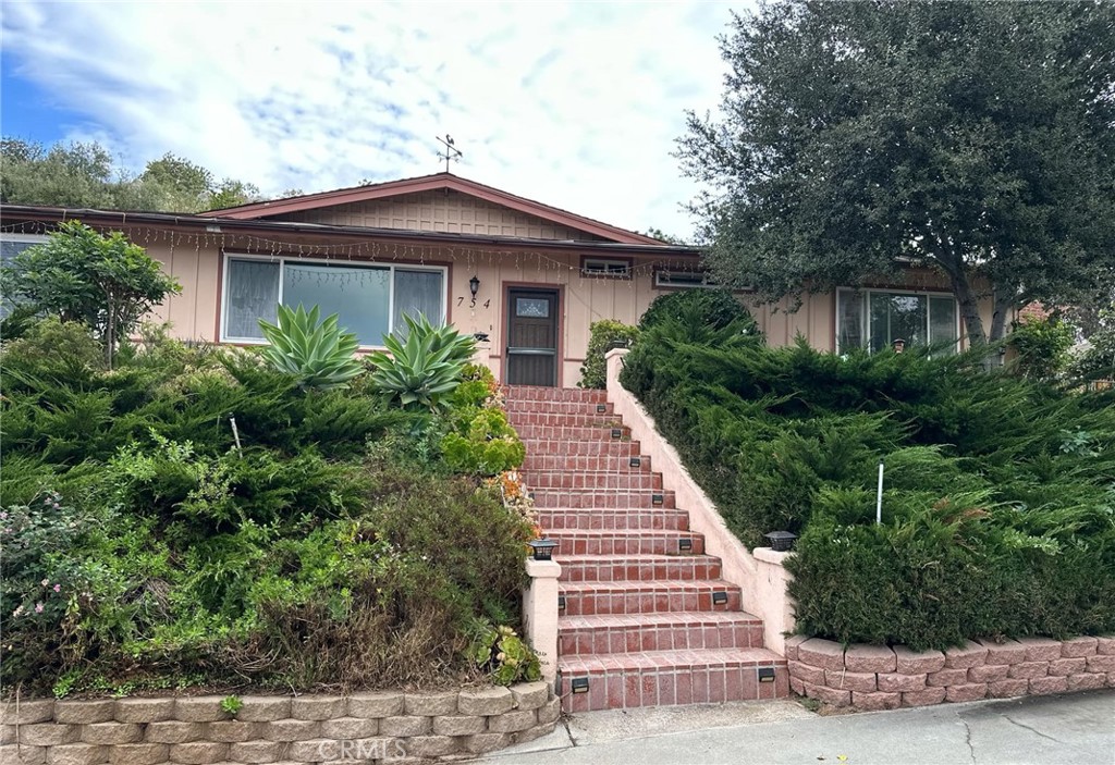 a front view of a house with plants