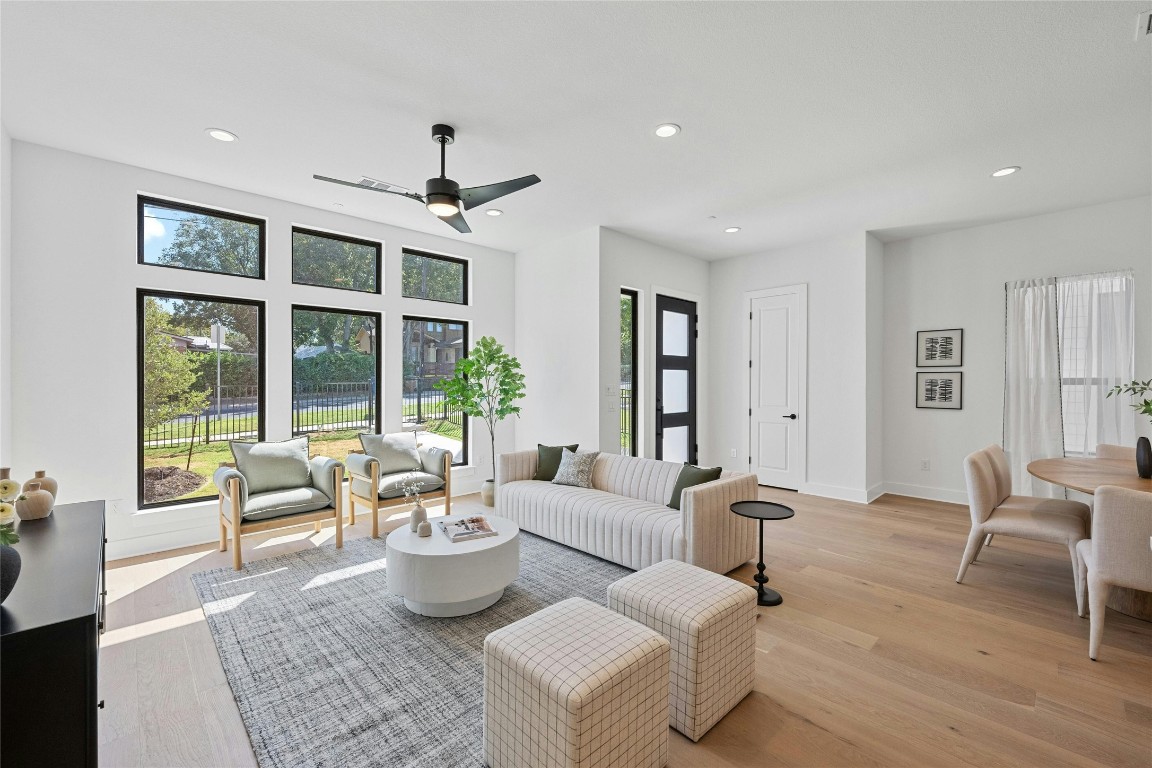 a living room with furniture windows and wooden floor