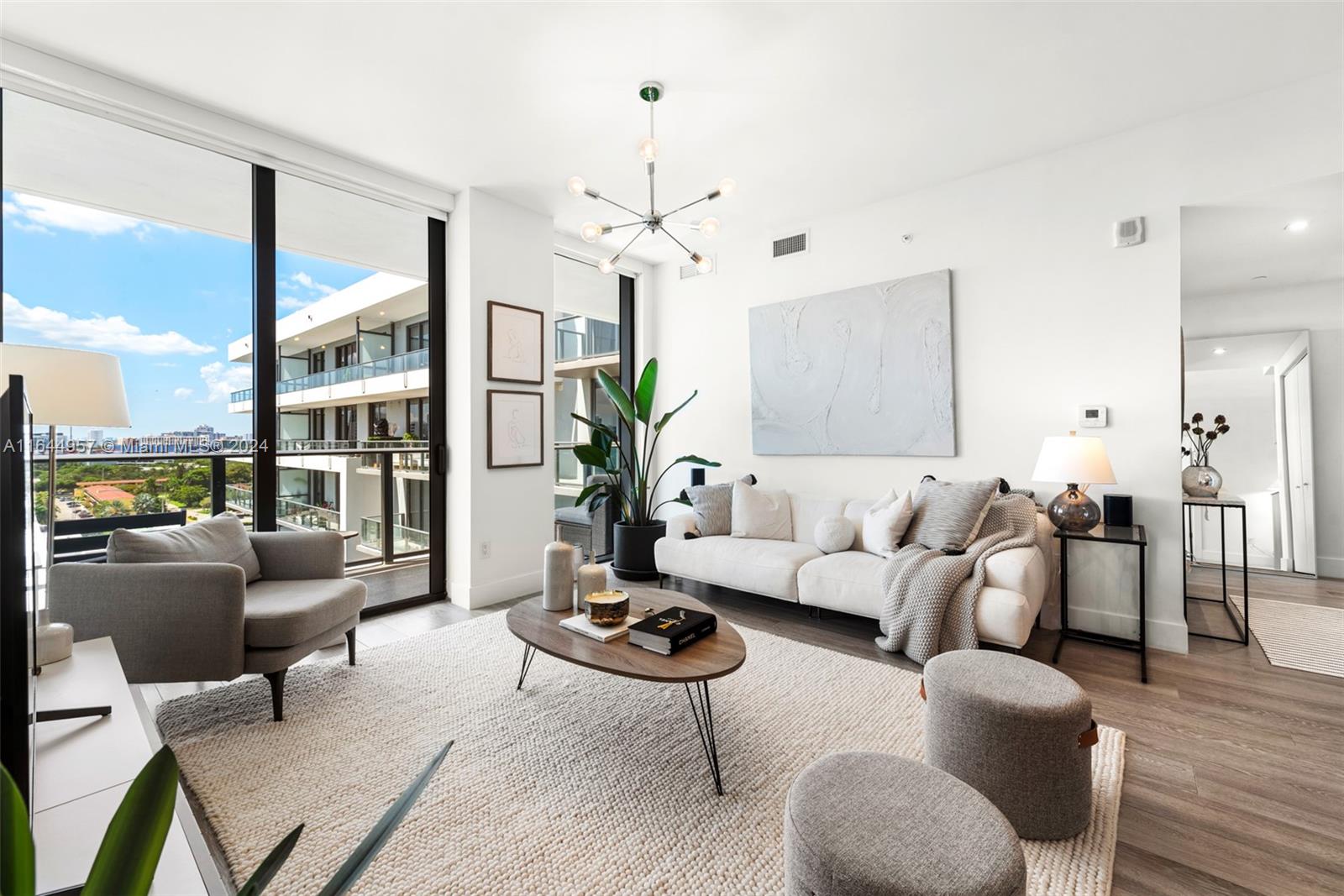 a living room with furniture a chandelier and a large window