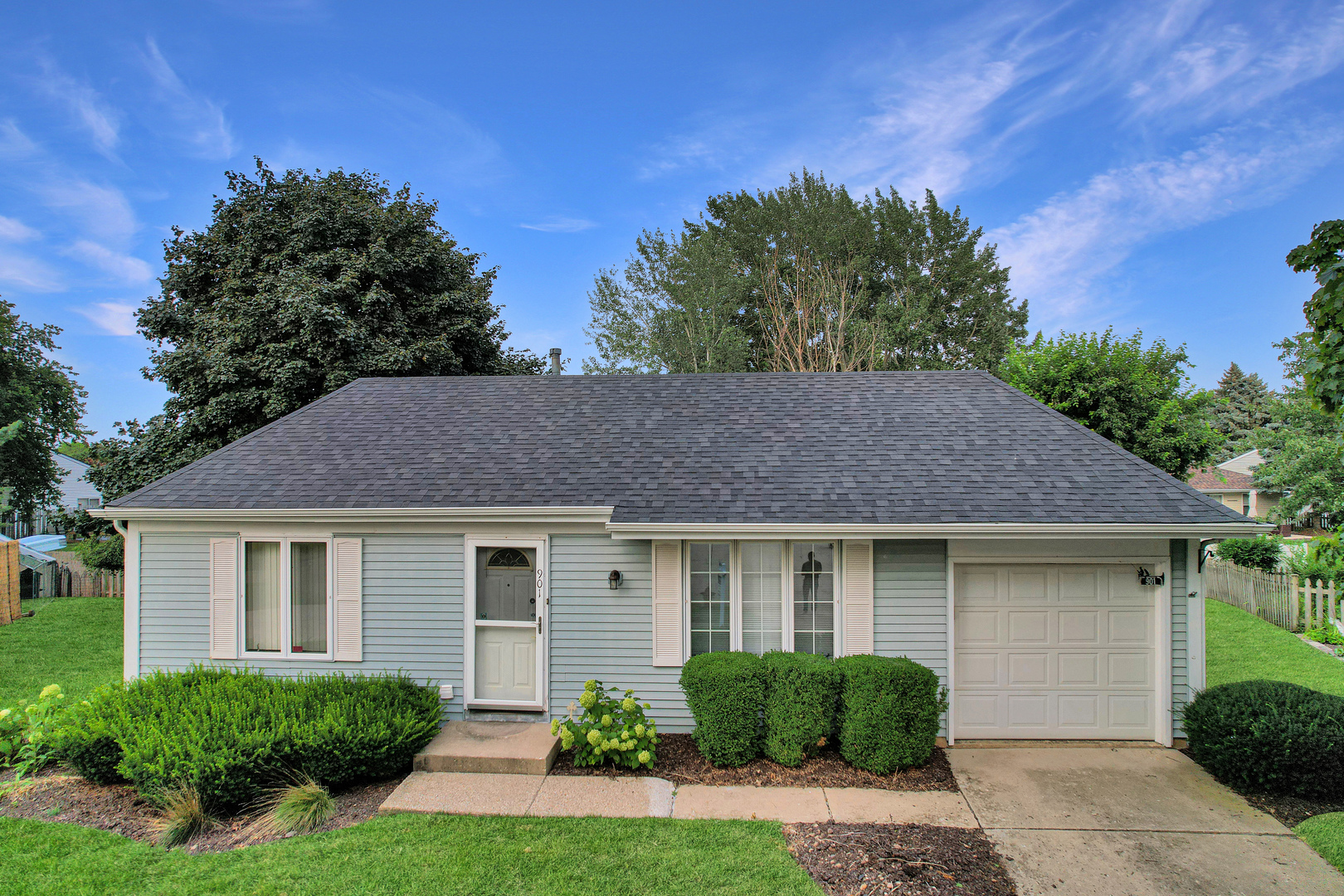 a front view of a house with a yard and trees