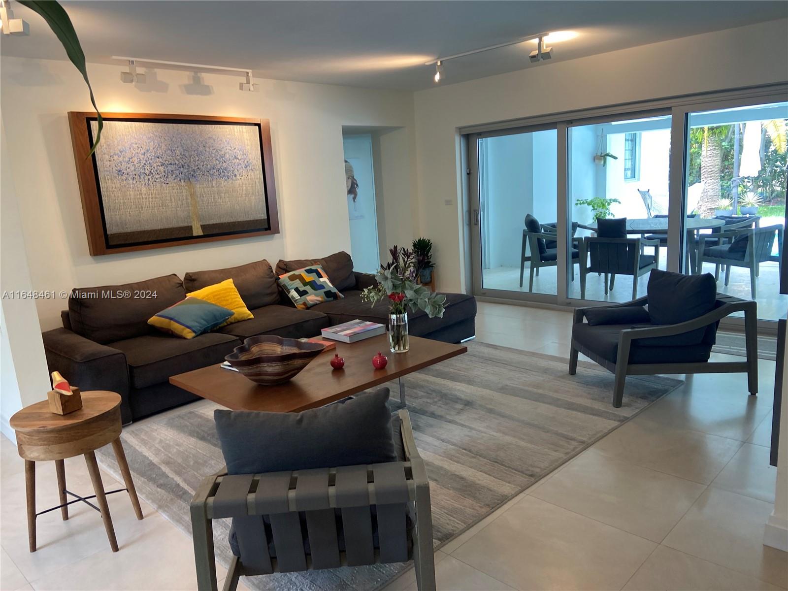 a living room with furniture and a floor to ceiling window