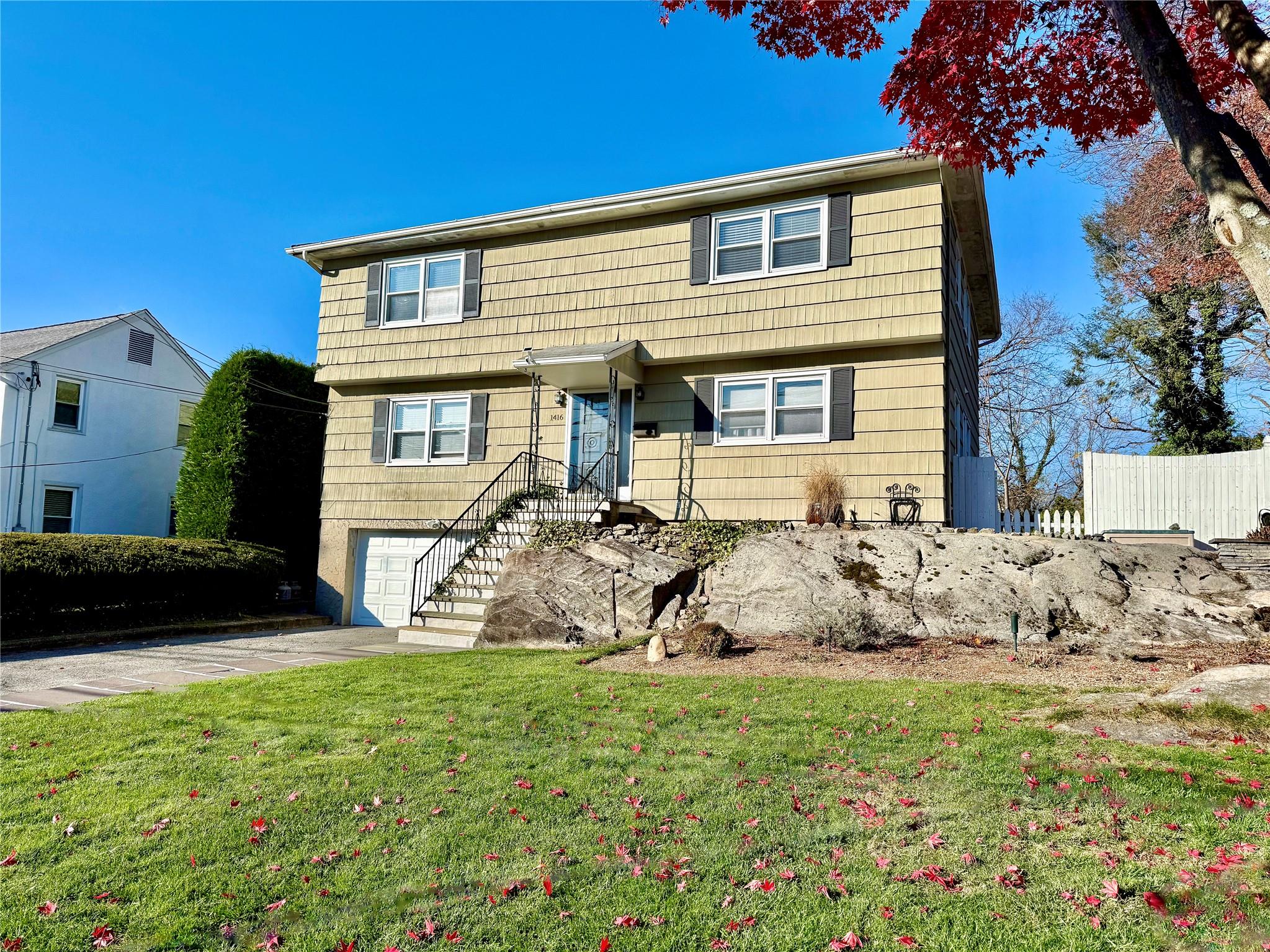 View of front of house with a front lawn and a garage