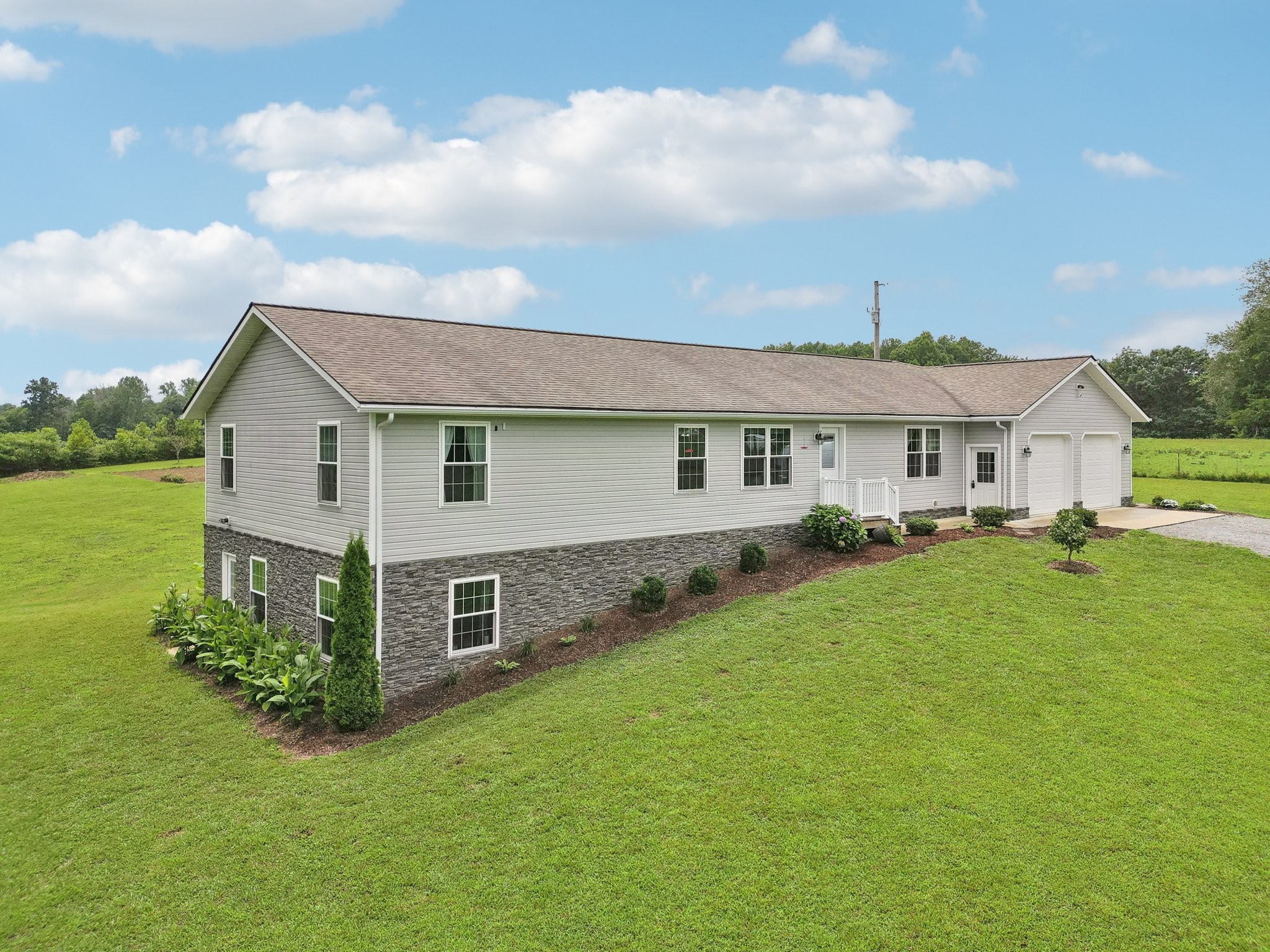 a view of a house with a big yard and large trees