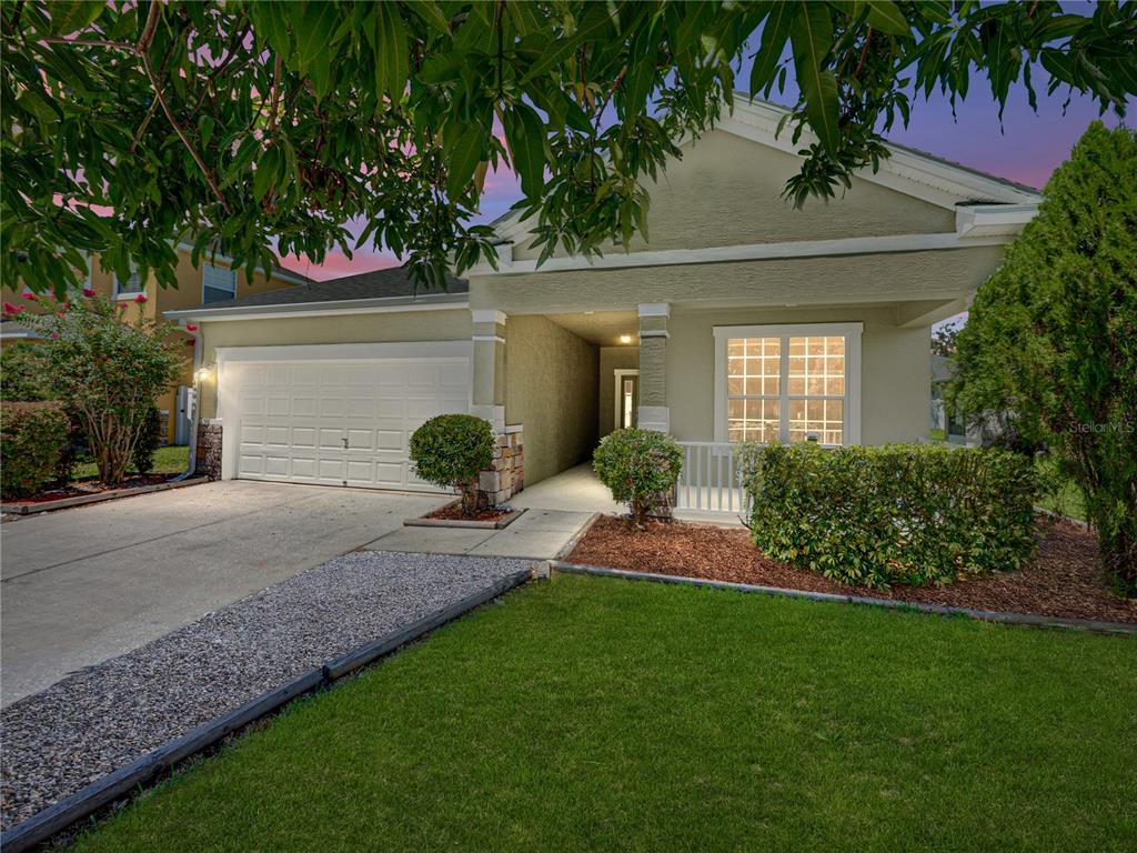 a front view of a house with a yard and potted plants