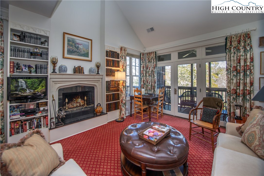 a living room with furniture a large window and a fireplace