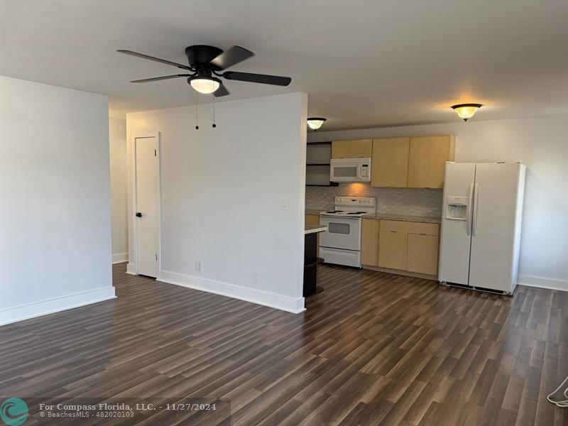 a view of a kitchen with a sink and a refrigerator