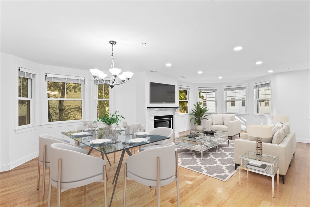 a view of a dining room with furniture a chandelier and wooden floor