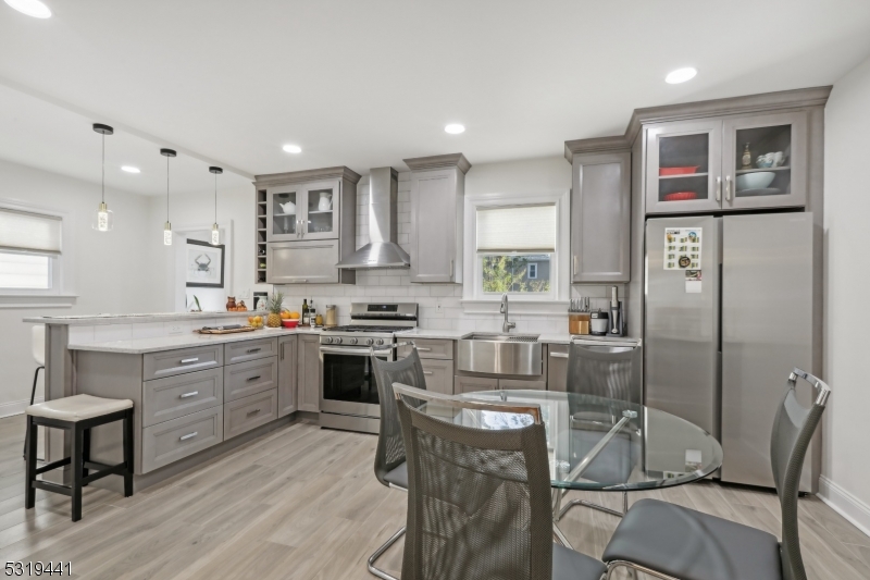 a kitchen with stainless steel appliances kitchen island granite countertop a stove a sink a refrigerator and cabinets