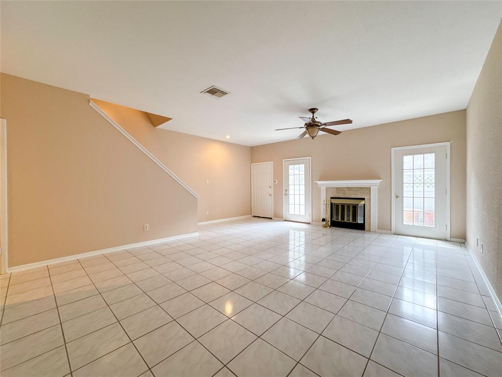 an empty room with windows and fireplace