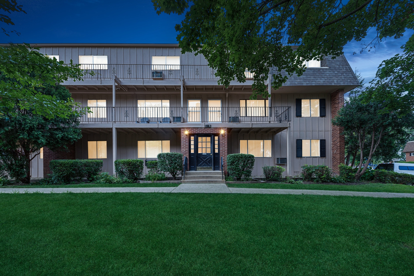 a front view of a residential apartment building with a yard