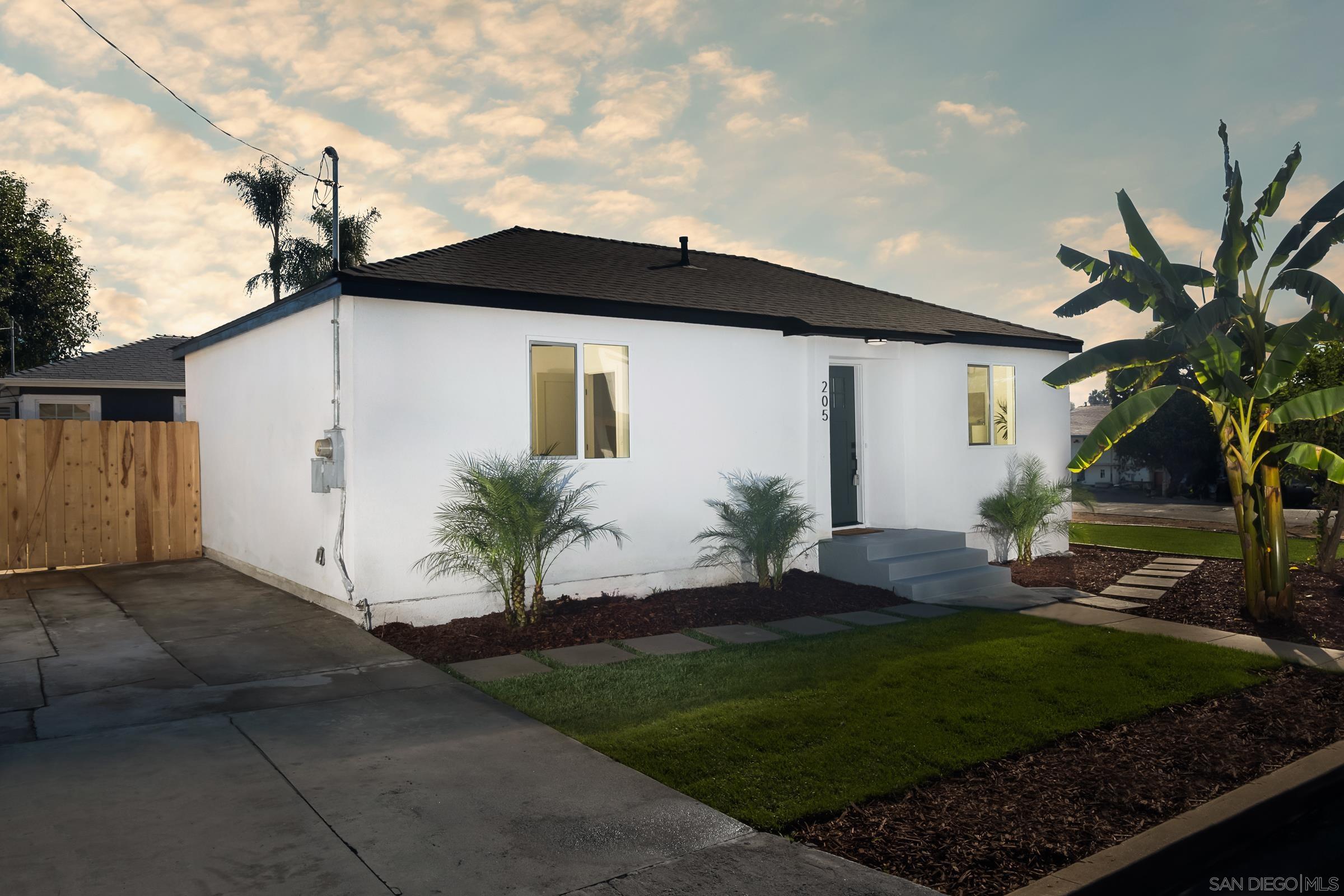 a front view of a house with a garden and yard