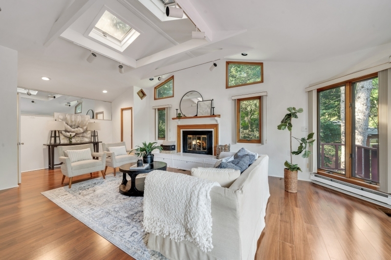 a living room with furniture large window and wooden floor