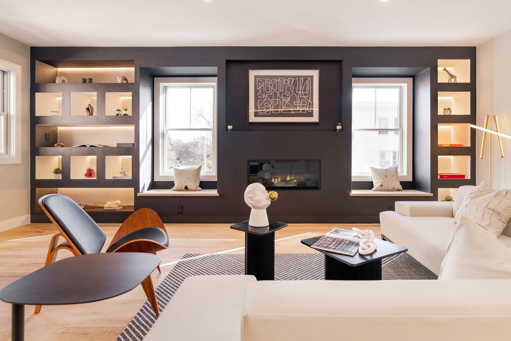 a living room with furniture fireplace and a large window