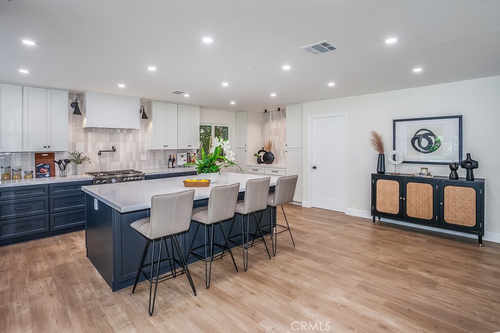 a kitchen with a dining table chairs and wooden floor