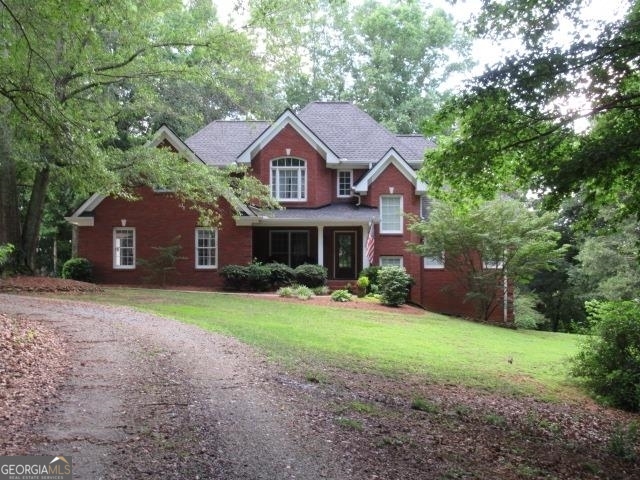 a front view of a house with yard and green space