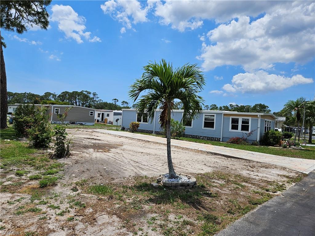 a front view of a house with a yard and trees