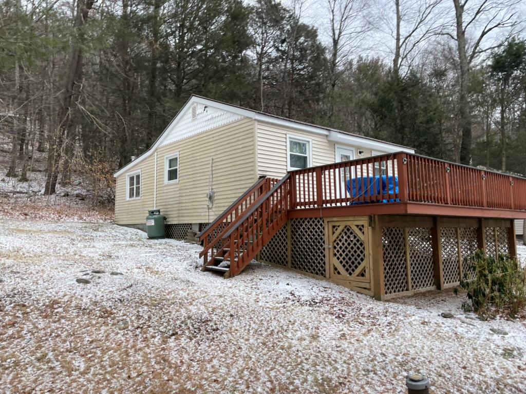 Snow covered property with a wooden deck