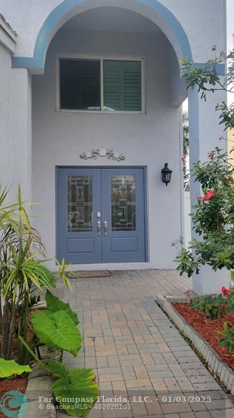 a front view of a house with lots of potted plants