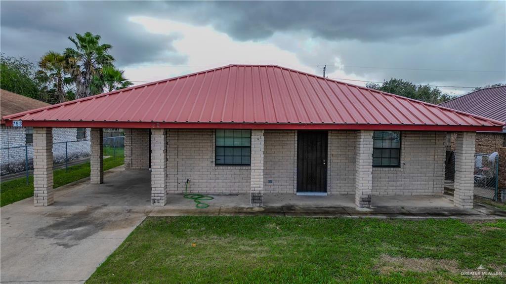 View of front of house featuring a front lawn and a carport