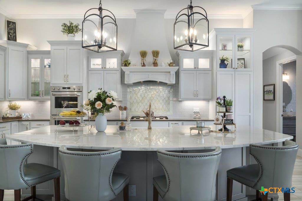 a kitchen with cabinets a table and chairs in it