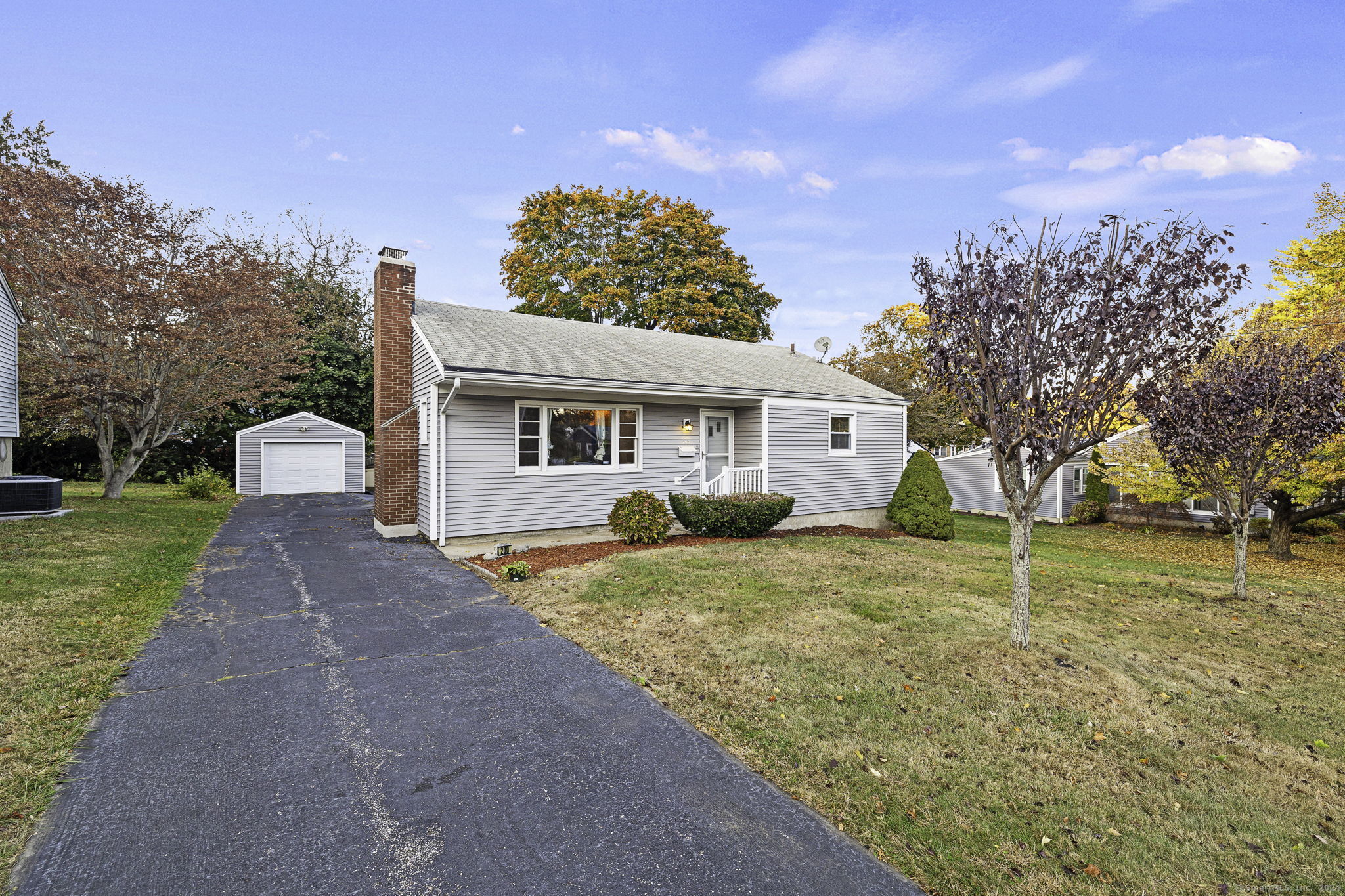 a view of a house with a yard and large tree