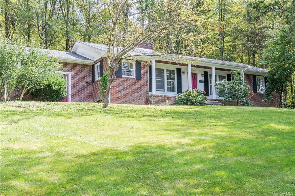 a front view of a house with a yard and trees