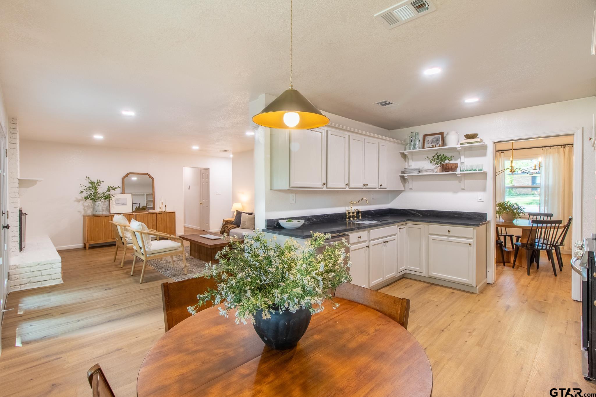 a kitchen with a refrigerator and a living room