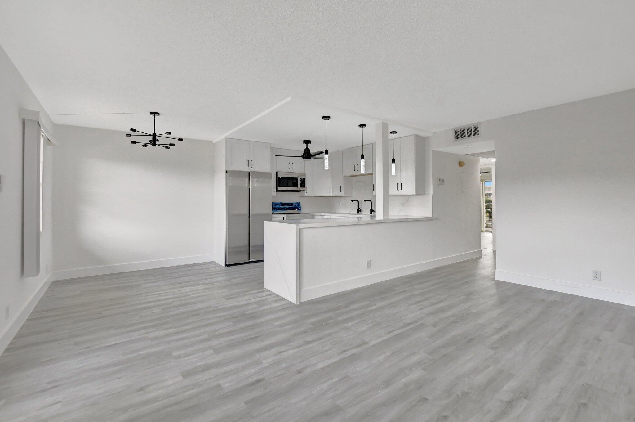 a view of a kitchen with wooden floor and a refrigerator