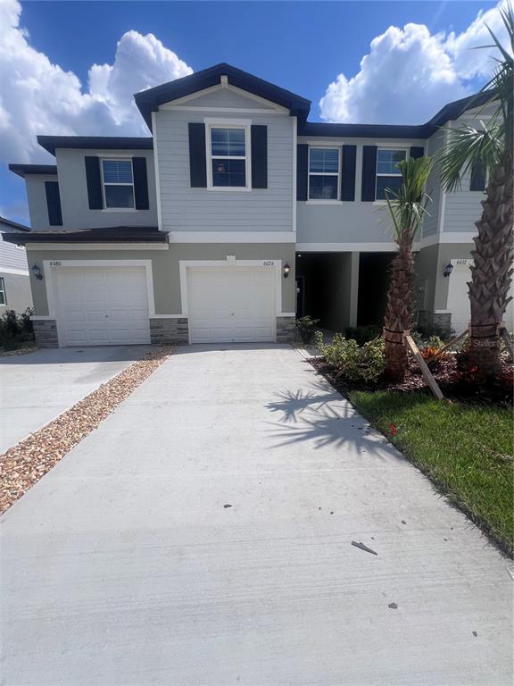 a front view of a house with a yard and a garage