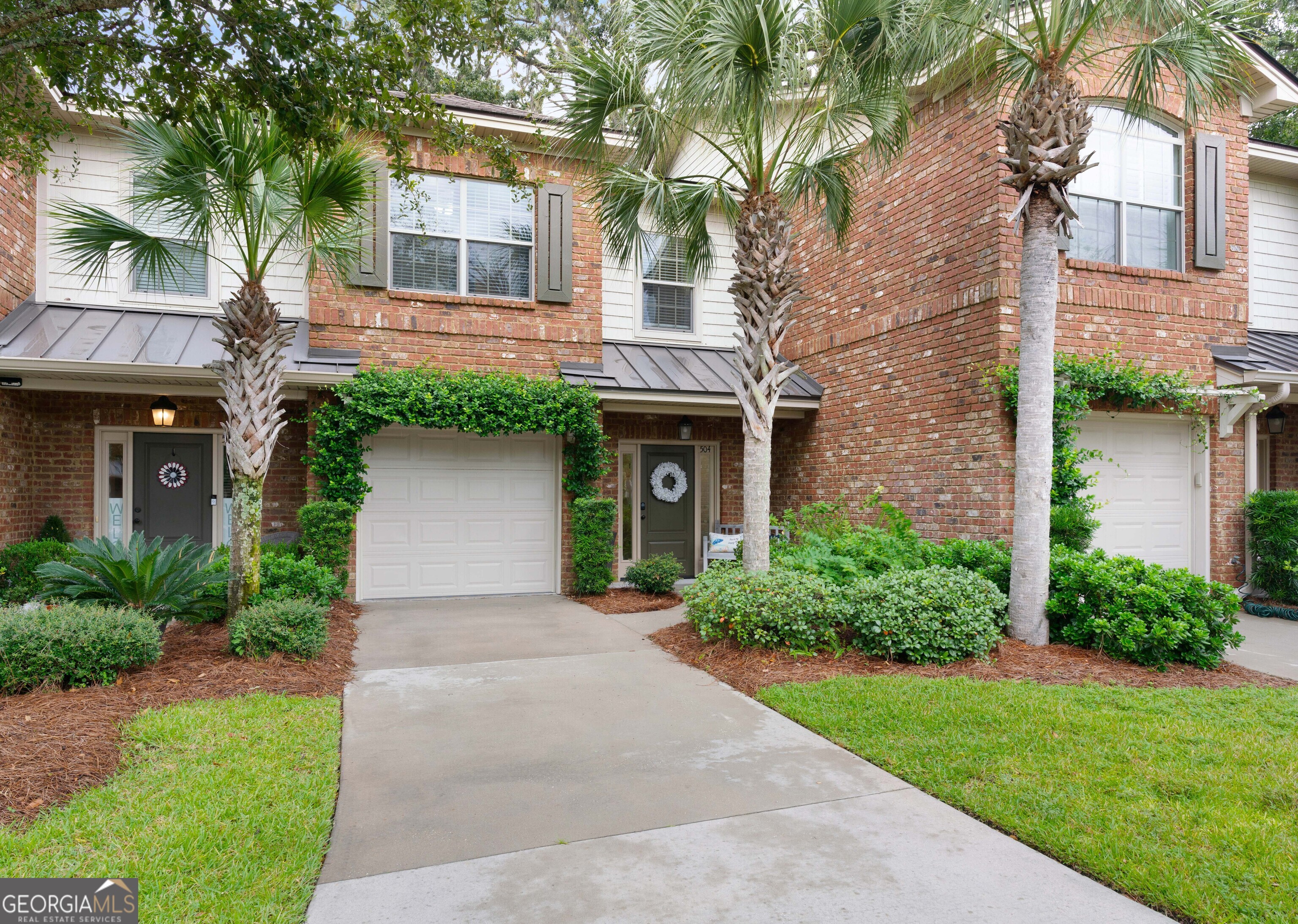 front view of a house with a yard and an trees