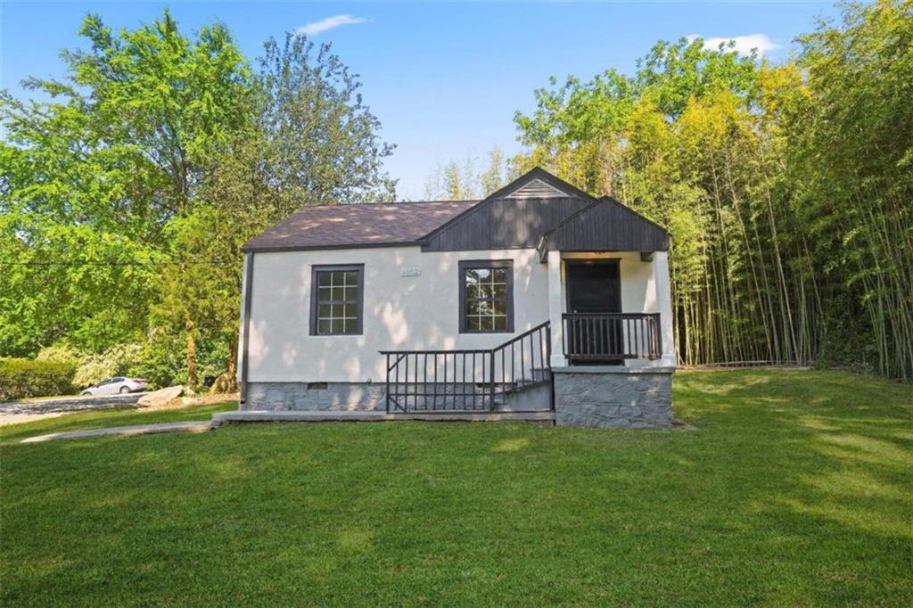 a view of a house with a yard and sitting area